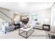 Open-concept living room with a view into the kitchen, featuring stylish furniture and neutral decor at 1233 Homecoming Blvd # Cc2-1-34, Ravenel, SC 29470