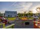 Outdoor brick firepit and lounging chairs with clubhouse in background at 1233 Homecoming Blvd # Cc2-1-34, Ravenel, SC 29470