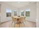 Bright dining area with large windows overlooking the backyard and a stylish round table with seating for six at 127 Oyster Tide Ave, Summerville, SC 29485