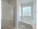 Bright bathroom features a shower with glass door, and a large soaking tub with a window at 1338 Hopton Cir, Mount Pleasant, SC 29466