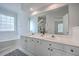 Bright, neutral bathroom features double vanity with white countertops and cabinets, and a large mirror at 1338 Hopton Cir, Mount Pleasant, SC 29466