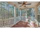 Covered porch includes ceiling fan and two chairs with floral throw pillows, overlooking a wooded area at 1338 Hopton Cir, Mount Pleasant, SC 29466