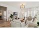 Open-concept living room with lots of seating, modern lighting, and hardwood flooring at 136 Post Mill Dr, Summerville, SC 29485
