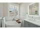 Bright bathroom with a soaking tub by the window, gray vanity and tiled floors at 1425 Lagoon Park Cir, Mount Pleasant, SC 29466