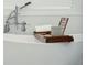 Close-up of a stylish white bathtub with a wooden tray holding a towel and mug at 1425 Lagoon Park Cir, Mount Pleasant, SC 29466
