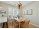 A dining room with a wood table, bench seating, and unique light fixture is brightened by natural light from the window at 1425 Lagoon Park Cir, Mount Pleasant, SC 29466