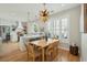 Open-concept dining area with kitchen view features a modern light fixture, wood table, and seating for casual and formal dining at 1425 Lagoon Park Cir, Mount Pleasant, SC 29466