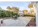 Secluded backyard with a stone patio, a dining set, lush greenery, mature trees, and surrounding neighboring houses at 146 S Battery St, Charleston, SC 29401