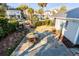 Aerial view of a backyard with stone patio, green grass, and an outdoor dining table surrounded by lush landscaping at 146 S Battery St, Charleston, SC 29401