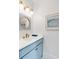 Stylish bathroom with a blue vanity, round mirror, and gold accents at 146 S Battery St, Charleston, SC 29401