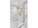 Walk-in shower featuring gold hardware, mosaic tile floor, and white marble tile at 146 S Battery St, Charleston, SC 29401
