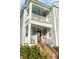 View of the home's double porches, complemented by window boxes, decorative light fixtures, and charming brick stairs at 146 S Battery St, Charleston, SC 29401