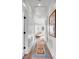 Bright hallway with hardwood floors, classic wainscoting, and colorful runner rug leading to a naturally lit living area at 146 S Battery St, Charleston, SC 29401