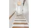 Bright staircase with wooden handrail, white risers, and wooden treads leading to the upper level at 146 S Battery St, Charleston, SC 29401
