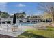 Large community pool surrounded by lush greenery, lounge chairs and palm trees on a sunny day at 1600 Long Grove Dr # 1727, Mount Pleasant, SC 29464