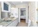 Stylish bathroom featuring green marble countertops, white cabinets and decorative wallpaper at 176 Marsh Hawk Ln, Kiawah Island, SC 29455