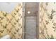 Well-lit bathroom with a glass shower door and floral-patterned wallpaper at 176 Marsh Hawk Ln, Kiawah Island, SC 29455