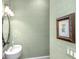 Elegant powder room featuring decorative wallpaper, stylish light fixtures, and an ornate mirror at 176 Marsh Hawk Ln, Kiawah Island, SC 29455