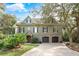 Charming home with a two-car garage, brick accents, and mature landscaping at 176 Marsh Hawk Ln, Kiawah Island, SC 29455