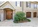 Elegant entryway with a wood door, brick accents, and manicured shrubbery at 176 Marsh Hawk Ln, Kiawah Island, SC 29455