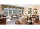 Bright living room with large windows, seating, and a fireplace at 176 Marsh Hawk Ln, Kiawah Island, SC 29455