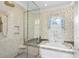 Inviting bathroom featuring a glass-enclosed shower and a soaking tub, with natural light and elegant fixtures at 176 Marsh Hawk Ln, Kiawah Island, SC 29455