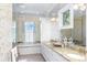 Luxe bathroom featuring a large tub, double sinks with granite counters, and a bright, airy ambiance at 176 Marsh Hawk Ln, Kiawah Island, SC 29455