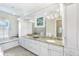 Bright bathroom with double sinks, granite countertop, soaking tub, and white cabinets at 176 Marsh Hawk Ln, Kiawah Island, SC 29455