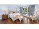 Tranquil main bedroom with a four-poster bed, large windows, and soft blue walls at 176 Marsh Hawk Ln, Kiawah Island, SC 29455