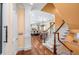 Entryway with wood floor and staircase leading to the upper level, kitchen in background at 176 Marsh Hawk Ln, Kiawah Island, SC 29455