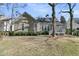 Charming home exterior with a screen porch, and lush backyard with mature trees at 1992 Pierce St, Charleston, SC 29492