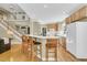 Open kitchen with bar seating, wooden cabinets, and a staircase to the second floor at 1992 Pierce St, Charleston, SC 29492