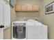 Bright laundry room featuring a washer and dryer with wooden cabinets above at 1992 Pierce St, Charleston, SC 29492