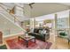 Open-concept living room with staircase, hardwood floors, and a view into the kitchen at 1992 Pierce St, Charleston, SC 29492