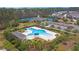 Aerial view of a large community pool, clubhouse, and nearby tennis courts amidst green trees at 2128 Baldwin Park Dr, Mount Pleasant, SC 29466