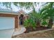 Inviting brick home featuring a decorative front door, two-car garage and tropical landscaping at 2128 Baldwin Park Dr, Mount Pleasant, SC 29466