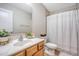 Cozy bathroom with a light wood vanity, potted plants, and a bathtub with a shower at 222 Medford Dr, Summerville, SC 29485