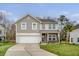 Charming two-story home featuring a manicured lawn, stone accents, and a two-car garage at 222 Medford Dr, Summerville, SC 29485