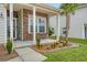 Inviting front porch featuring stone accents, a palm tree, and flower beds at 222 Medford Dr, Summerville, SC 29485