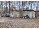 Backyard featuring sheds and debris surrounded by mature trees at 223 Fox Field Rd, Walterboro, SC 29488