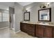 Traditional bathroom with double sink vanity, framed mirrors, and tiled floors at 223 Fox Field Rd, Walterboro, SC 29488