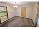 A dining room featuring neutral carpet and curtains, with a view into the kitchen at 228 Jean Wells Dr, Goose Creek, SC 29445