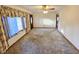Bright living room with neutral carpet, large windows, and a doorway leading to another room, creating a warm ambiance at 228 Jean Wells Dr, Goose Creek, SC 29445
