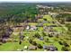 A wide aerial shot captures a beautiful forest behind homes with green lawns and outbuildings at 2285 Cooper Store Rd, Moncks Corner, SC 29461