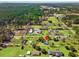 A wide aerial shot captures a beautiful forest behind homes with green lawns and outbuildings at 2285 Cooper Store Rd, Moncks Corner, SC 29461