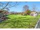 Backyard featuring sheds, green house, a grassy area, and a small deck under a bright sky at 2285 Cooper Store Rd, Moncks Corner, SC 29461