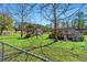 Backyard showcasing play set, greenhouse, and deck surrounded by grass and trees on a sunny day at 2285 Cooper Store Rd, Moncks Corner, SC 29461