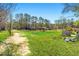 Sprawling property with mature trees, a dirt path, and a mix of buildings and open fields at 2285 Cooper Store Rd, Moncks Corner, SC 29461