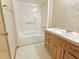 Cozy bathroom featuring a shower-tub combo, wood vanity, and patterned wallpaper at 243 Country Club Blvd, Saint George, SC 29477