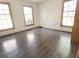 Bright bedroom features beautiful hardwood floors, baseboard trim and three large windows at 243 Country Club Blvd, Saint George, SC 29477